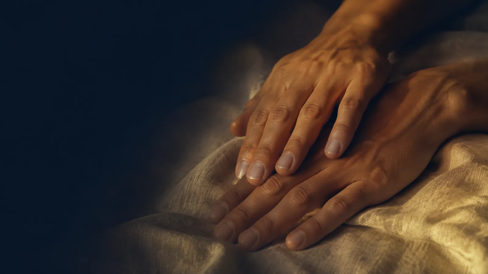 Deux mains posées l'une sur l'autre sur du lin, massage tantrique pour couple