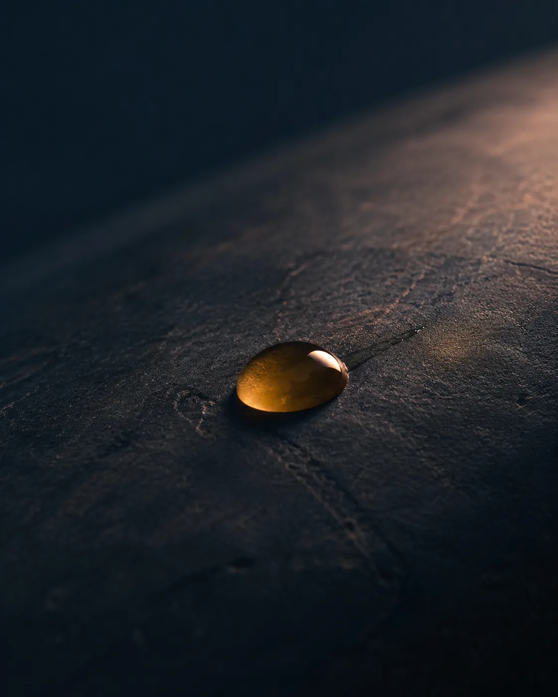 Goutte d'huile dorée sur la pierre, image du massage tantrique