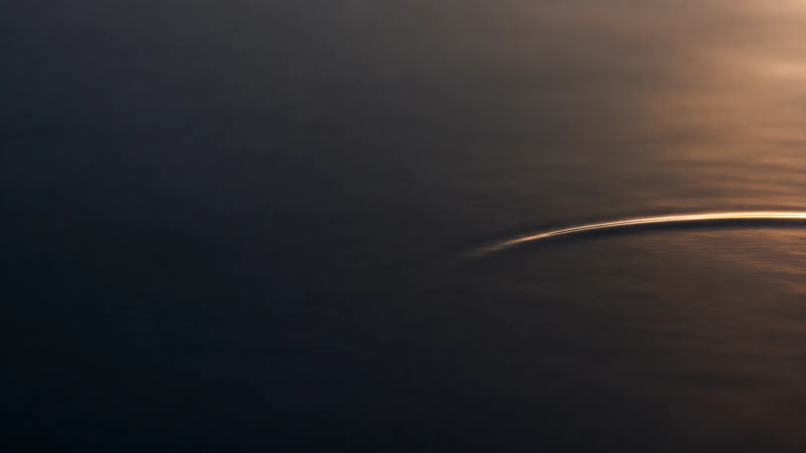 Surface d'eau calme et lumière dorée, image des bienfaits du tantra