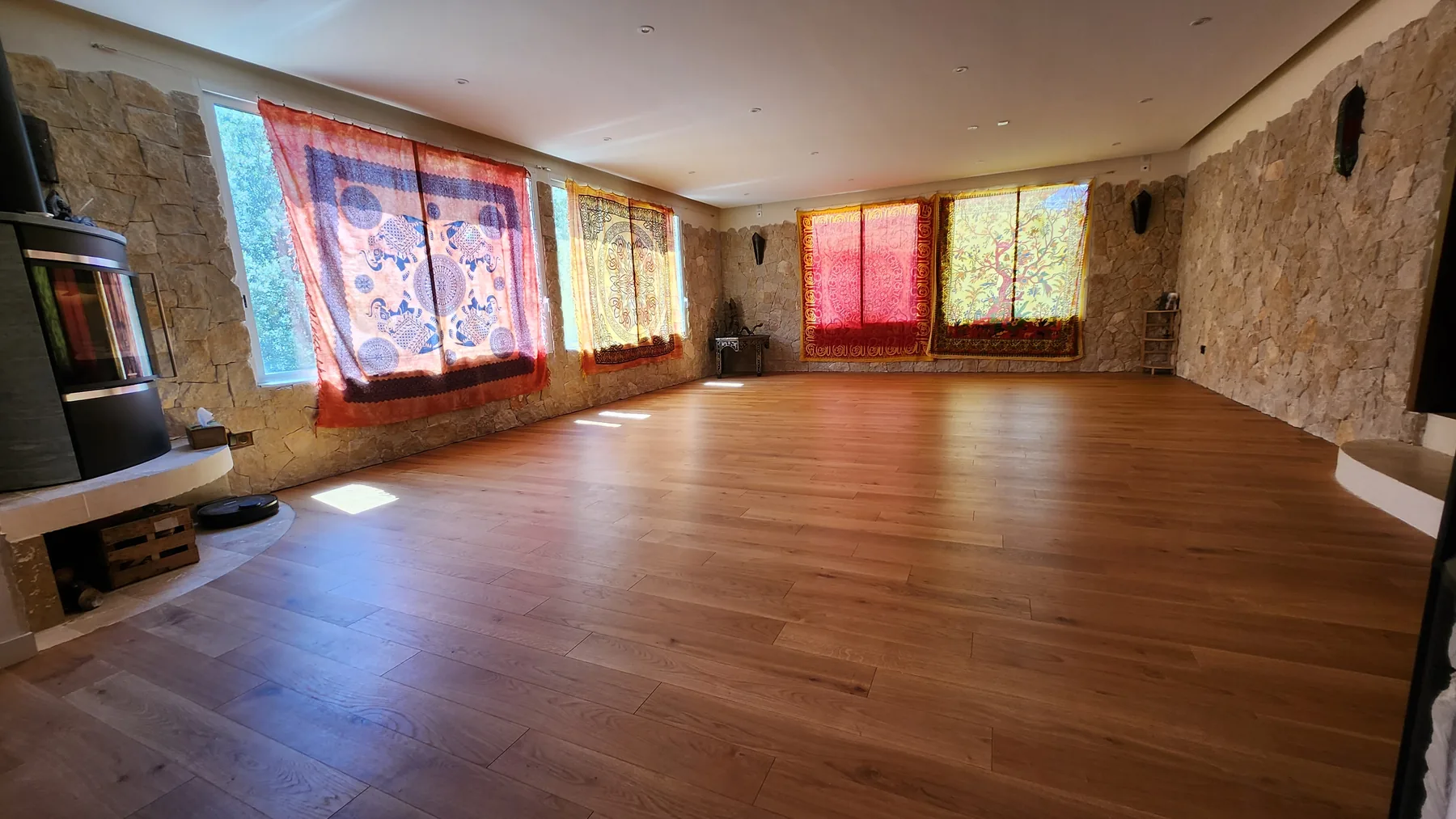 La salle de pratique, parquet et murs de pierre, poêle à bois